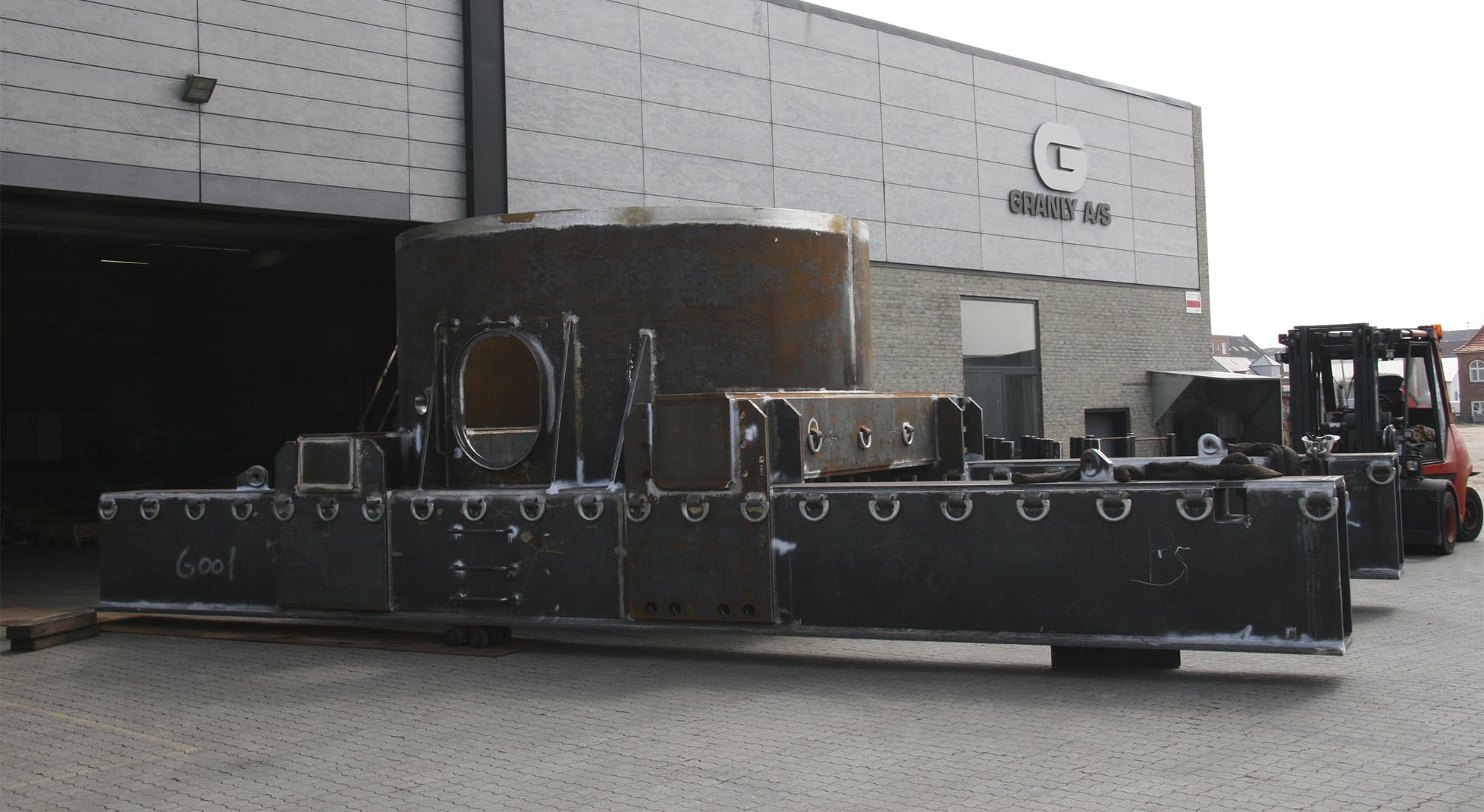 Fabricated steel transport equipment outside a Granly building, shown in its portfolio